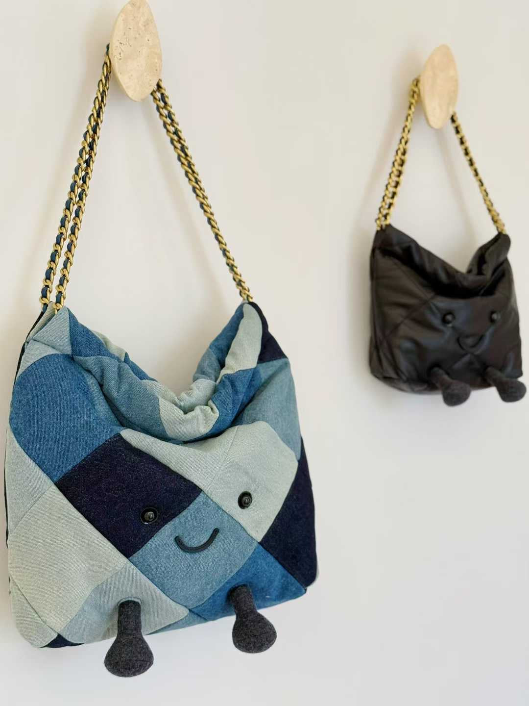 Two fabric bags with animal faces hanging on wooden hooks against a white wall.